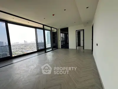 Spacious modern living room with panoramic city view and elegant flooring.
