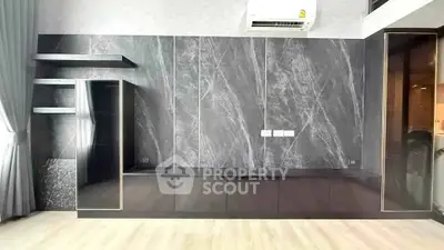 Modern living room with sleek black marble wall and built-in shelves