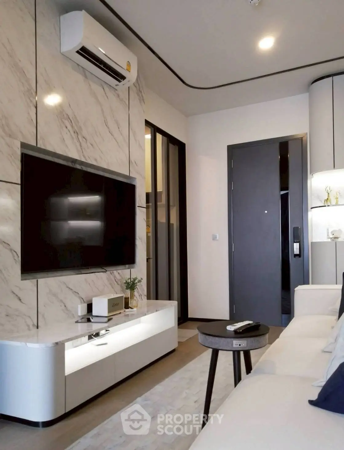 Modern living room with marble accent wall, sleek TV setup, and stylish furniture.