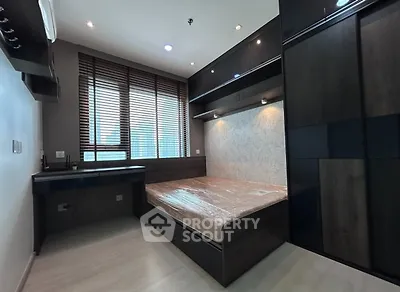 Modern bedroom with sleek dark wood furniture and large window blinds