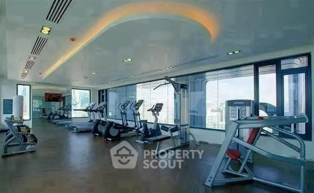 Spacious modern gym with city view and state-of-the-art equipment.