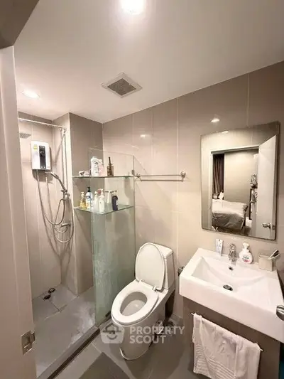 Modern bathroom with sleek fixtures and glass shower in contemporary apartment.