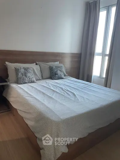 Cozy bedroom with modern decor and large window for natural light