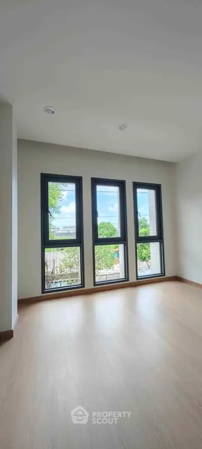 Bright and spacious room with large windows offering a scenic view, perfect for a modern living space.