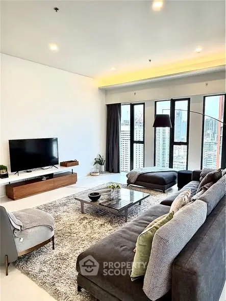 Spacious modern living room with city view, stylish furniture, and ample natural light.