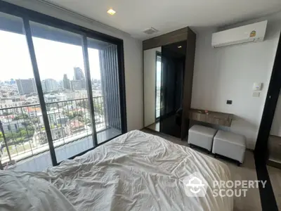 Modern bedroom with city view and balcony access, featuring sleek design and natural light.