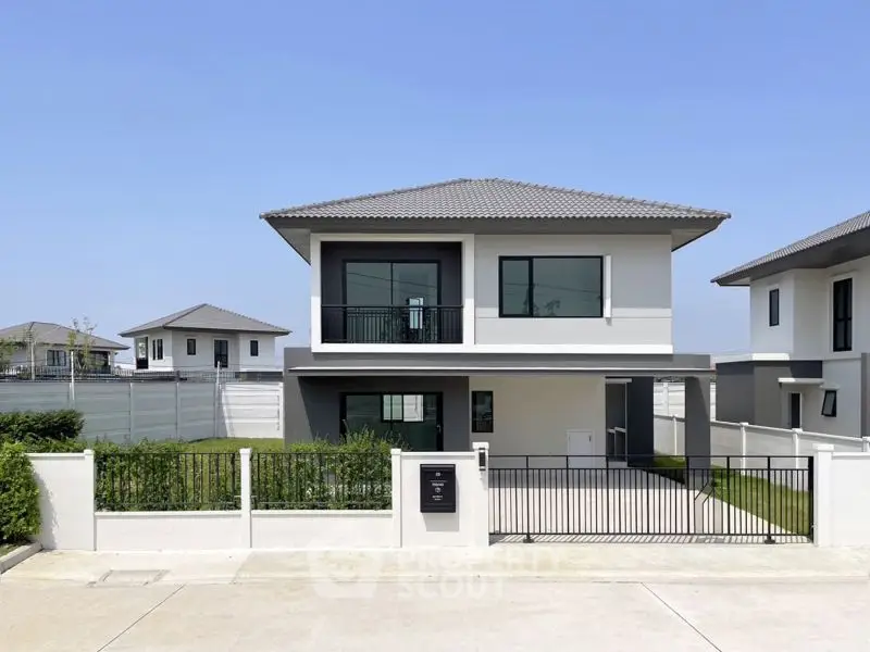 Modern two-story house with sleek design and spacious front yard in a serene neighborhood.