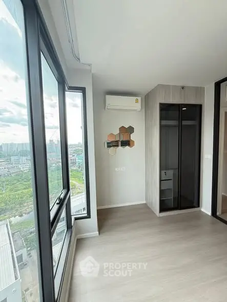 Modern apartment interior with large windows and air conditioning, offering a stunning city view.