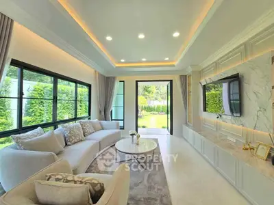 Luxurious living room with elegant decor and garden view, featuring a plush sofa and modern entertainment setup.