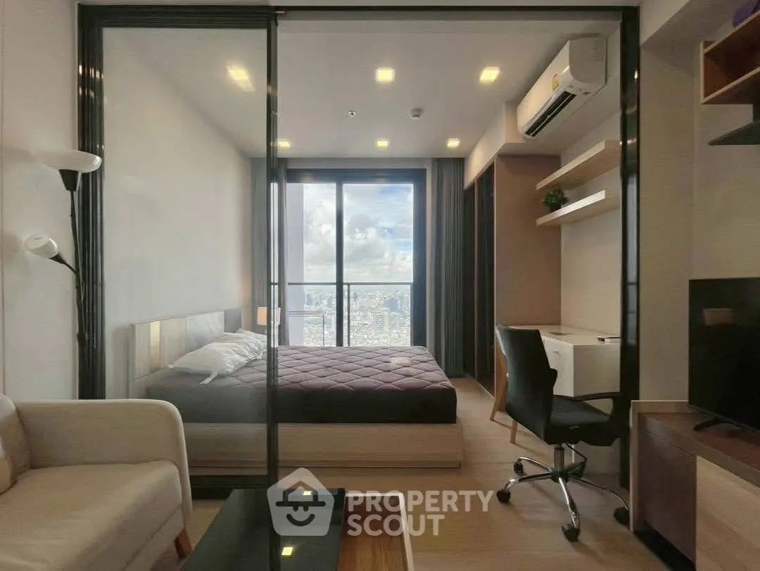 Modern bedroom with city view, featuring sleek furniture and glass partition for a spacious feel.