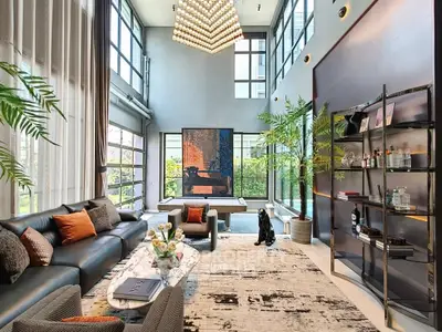 Luxurious modern living room with high ceilings, large windows, and elegant decor.