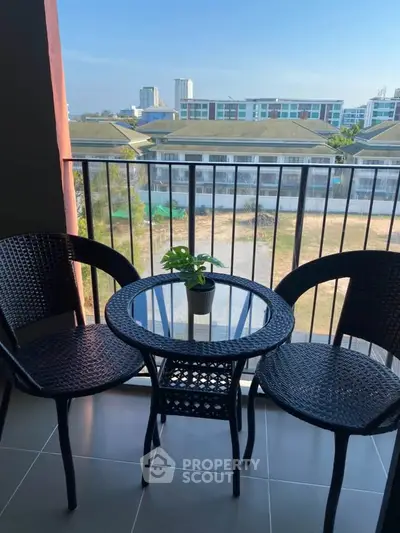 Charming balcony with outdoor seating and scenic view of modern buildings.