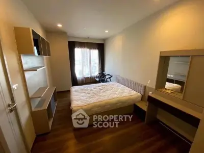 Modern bedroom with wooden flooring and stylish furniture in a cozy apartment.