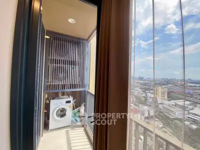 High-rise apartment with balcony featuring a washing machine and stunning city view.
