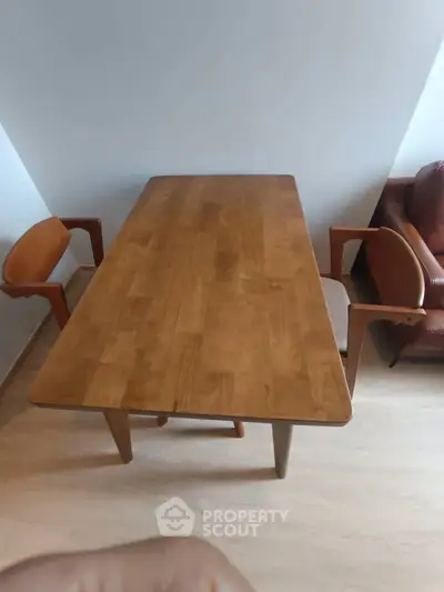 Modern wooden dining table with chairs in a stylish living room setting.