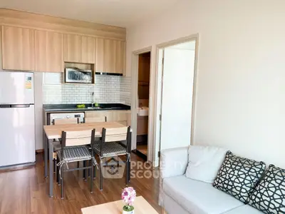 Modern open-plan kitchen and living room with stylish decor and wooden flooring.