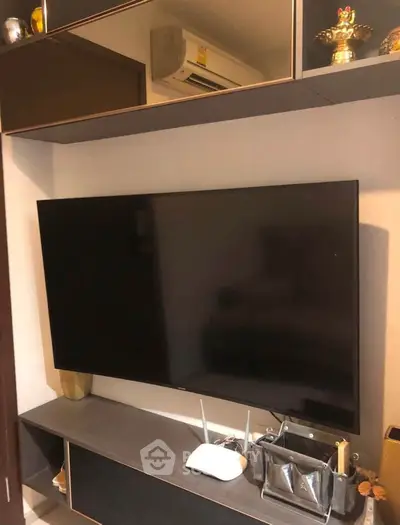 Modern living room with wall-mounted TV and sleek storage solutions.