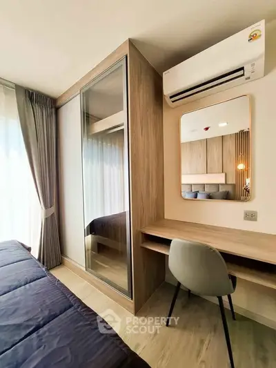Modern bedroom with sleek design, featuring a built-in wardrobe, desk, and air conditioning for ultimate comfort.