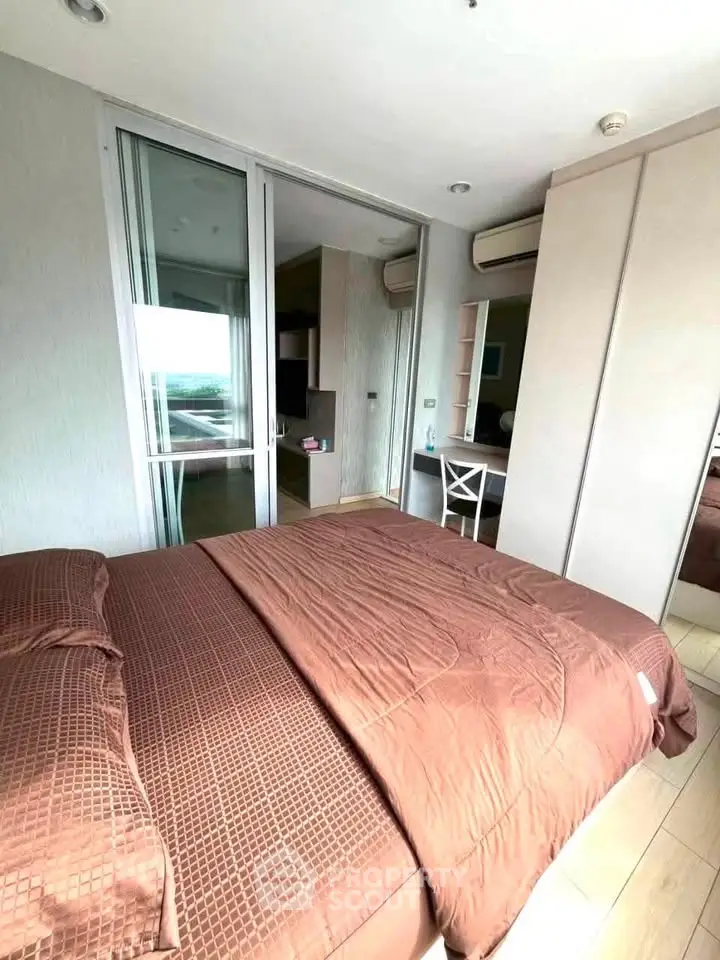 Modern bedroom with large window and stylish decor in a contemporary apartment.