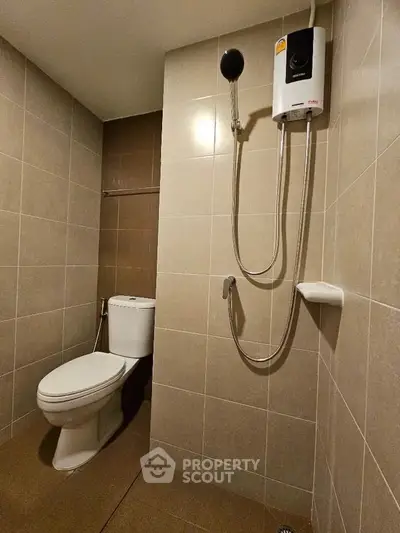 Modern bathroom with sleek tiles and shower heater in a contemporary apartment.