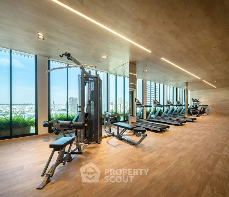 Luxurious gym with city view and modern equipment in high-rise building.