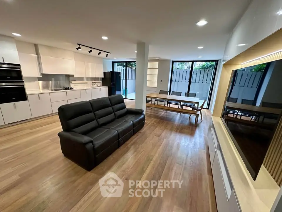 Modern open-plan living room with sleek kitchen and stylish furnishings