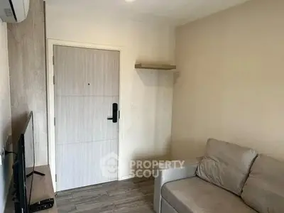 Cozy living room with modern sofa and wall-mounted TV, perfect for relaxation.