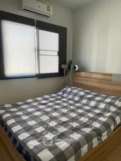 Cozy bedroom with modern air conditioning and stylish checkered bedding