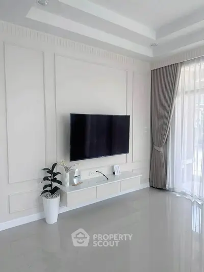 Modern living room with wall-mounted TV and elegant curtains