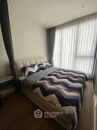 Modern bedroom with stylish decor and large window for natural light