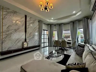 Luxurious living room with elegant marble wall and spacious seating area, perfect for modern living.