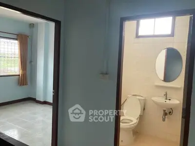 Cozy interior with bathroom and adjacent room, featuring natural light and simple design.