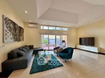 Spacious modern living room with elegant decor and large windows opening to a balcony.