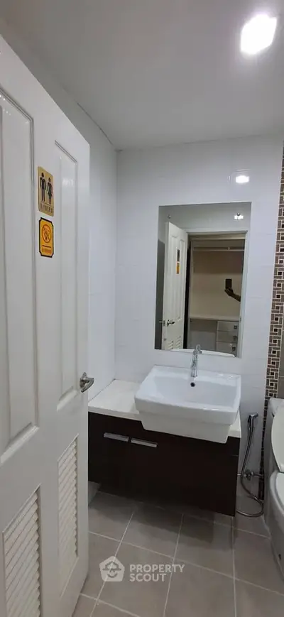 Modern bathroom with sleek sink and large mirror in a contemporary home.