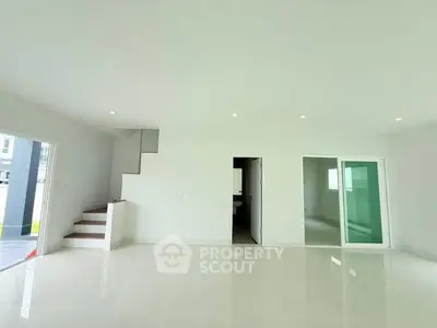 Spacious modern living room with sleek staircase and sliding glass doors