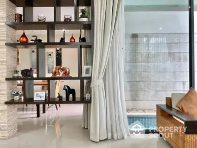 Elegant living room with decorative shelving and pool view, perfect for modern lifestyle.