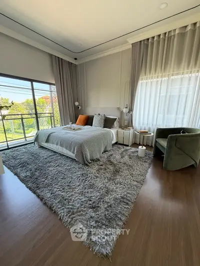 Spacious bedroom with large windows and balcony access, featuring modern decor and plush carpeting.