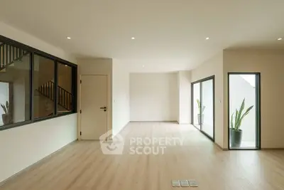 Spacious modern living room with large windows and wooden flooring