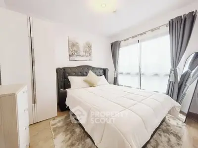 Cozy bedroom with elegant decor and large window for natural light.
