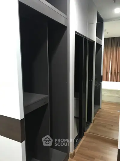 Spacious modern bedroom with sleek walk-in closet and wooden flooring