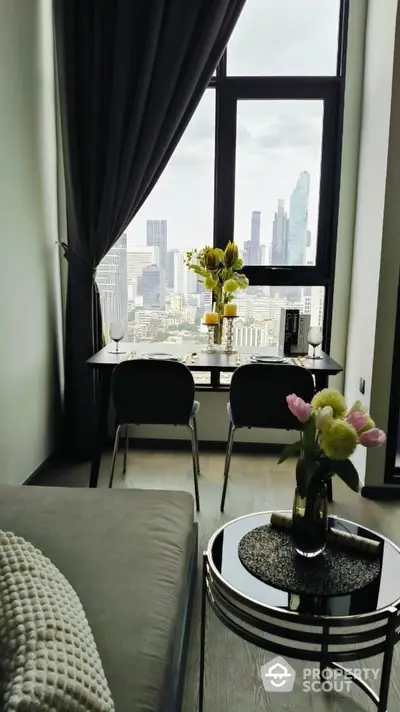 Modern apartment with stunning city view, elegant dining setup, and cozy living area.