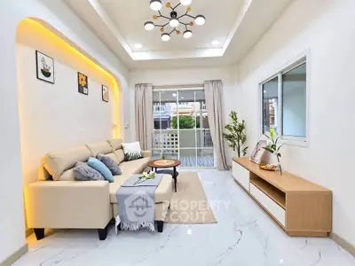 Modern living room with elegant lighting and cozy beige sofa, featuring a stylish open layout and large window view.