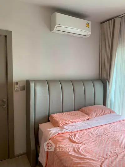 Cozy bedroom with modern air conditioning and stylish headboard, perfect for comfort and relaxation.