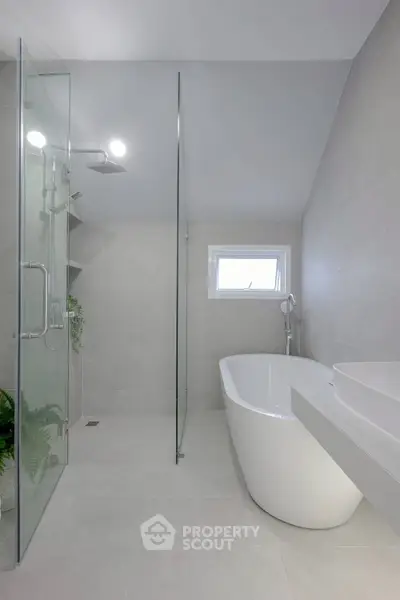 Modern bathroom with sleek glass shower and elegant freestanding bathtub.