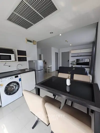 Modern open-plan kitchen and dining area with sleek appliances and stylish furniture.