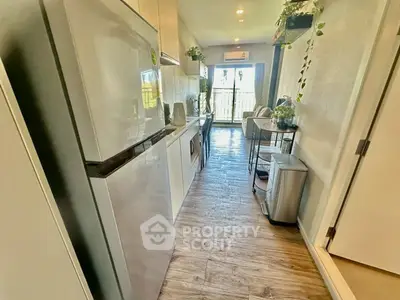 Modern kitchen with sleek appliances and open layout leading to balcony view.