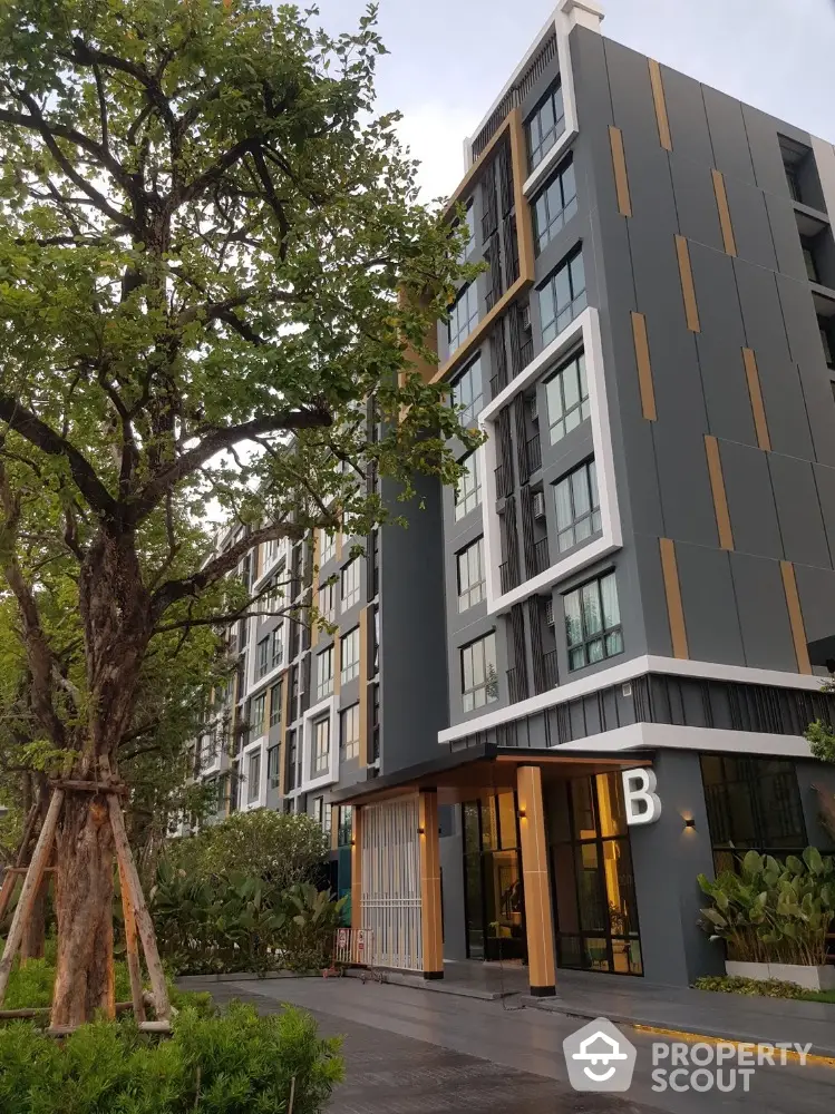 Modern apartment building exterior with lush greenery and sleek design