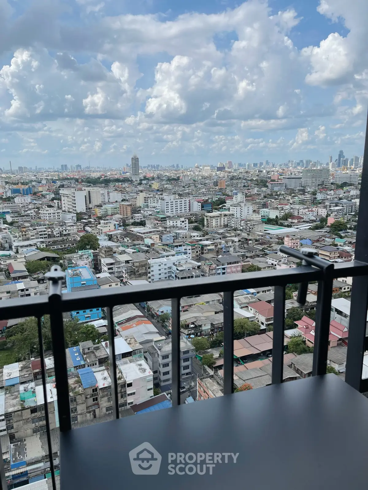 Stunning cityscape view from a high-rise balcony, showcasing urban skyline and vibrant city life.