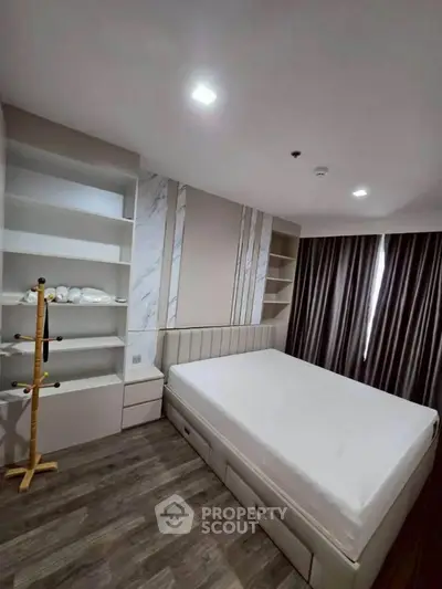 Modern bedroom with built-in shelves and stylish decor in a contemporary apartment.