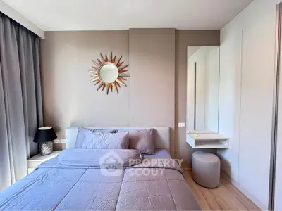 Modern bedroom with stylish decor and natural light, featuring a cozy bed and elegant furnishings.